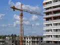 Budowa nowego osiedla przez lex deweloper. Żuraw budowlany pracuje przy nowoczesnym bloku mieszkalnym.