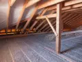 Strych z drewnianą konstrukcją i warstwą izolacji z celulozy. To materiał, który świetnie izoluje.