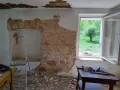Odkryty mur pruski w trakcie remontu. Widać cegły, gruz, drabinę i narzędzia.