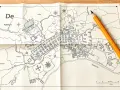 Ołówek spoczywa na złożonej mapa do celów projektowych przedstawiającej miasto z budynkami, rzeką i polami.