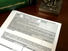 Zielona księga z tytułem "Kodeks postępowania cywilnego" i dokument z polami do wypełnienia.