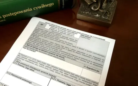Zielona księga z tytułem "Kodeks postępowania cywilnego" i dokument z polami do wypełnienia.