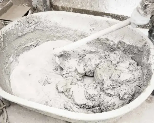 Mieszanie wapna gaszonego w dużej misie, tworząc gładką masę do prac budowlanych.