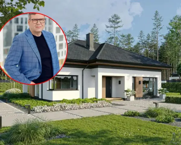 Mężczyzna w garniturze obok nowoczesnego domu. Dowiedz się, jaki jest koszt budowy domu 150m2.