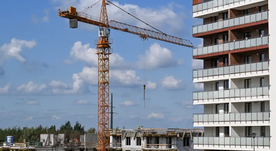 Budowa nowego osiedla przez lex deweloper. Żuraw budowlany pracuje przy nowoczesnym bloku mieszkalnym.