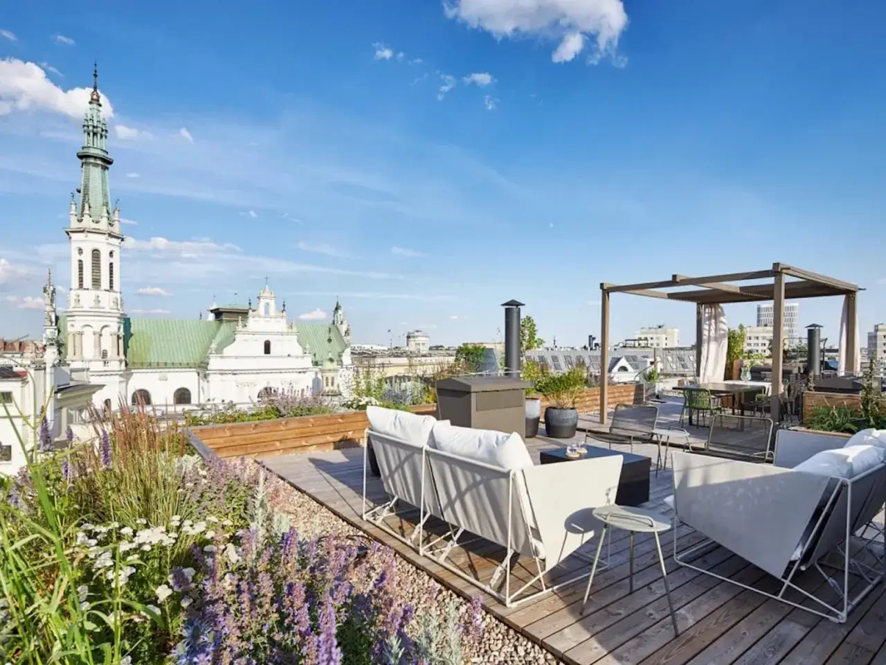 Luksusowe penthousy oferują tarasy z widokiem na zabytkową architekturę. Wygodne meble i zieleń tworzą oazę spokoju.
