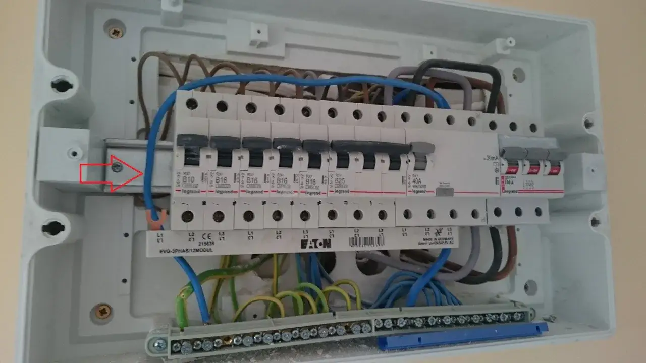 Wnętrze rozdzielnicy elektrycznej z widocznymi bezpiecznikami i przewodami. Zabezpieczenie przedlicznikowe jest kluczowym elementem instalacji.