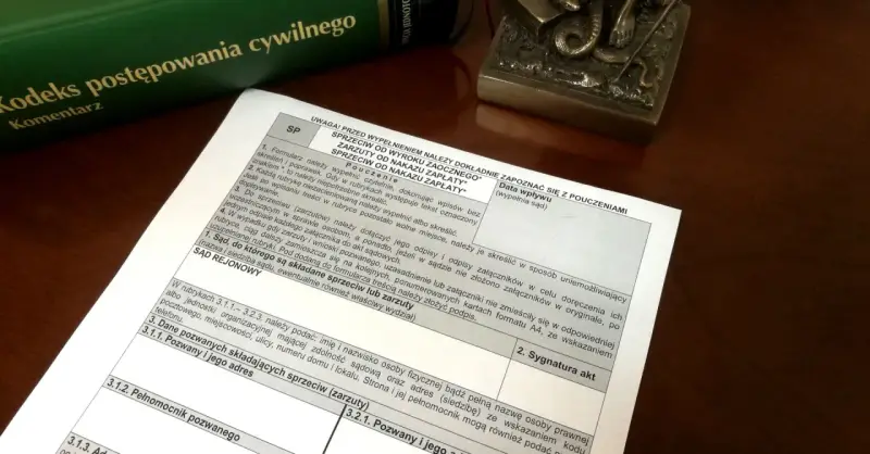 Zielona księga z tytułem "Kodeks postępowania cywilnego" i dokument z polami do wypełnienia.